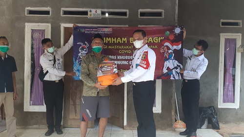 Mujiarto, Kepala Lapas Khusus kelas IIA Gunungsindur didampingi jajaran dan aparatur setempat membagikan paket bantuan sembako, vitamin dan masker gratis untuk warga terdampak pandemi covid 19