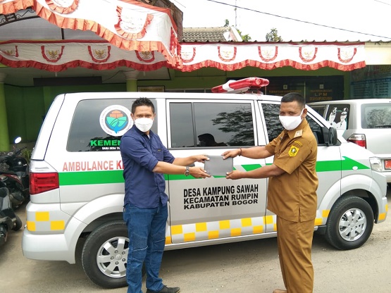 Kepala Desa Kampung Sawah Edi Riyadi berfoto saat menerima surat pembelian mobil ambulance