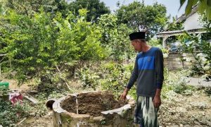 Ketua RT 2 RW 2 Desa Dago menunjukan sumur warga yang tercemar akibat terdampak banjir.
