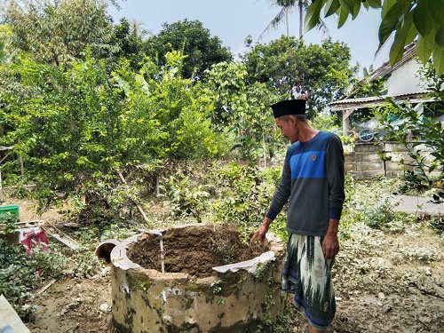 Ketua RT 2 RW 2 Desa Dago menunjukan sumur warga yang tercemar akibat terdampak banjir.