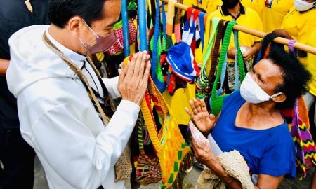 Presiden Jokowi membeli noken dari mama penjual di pinggir Jalan Raya Hawai Sentani, Jayapura, Papua, Jumat (01/10/2021). (Foto: BPMI Setpres/Laily)