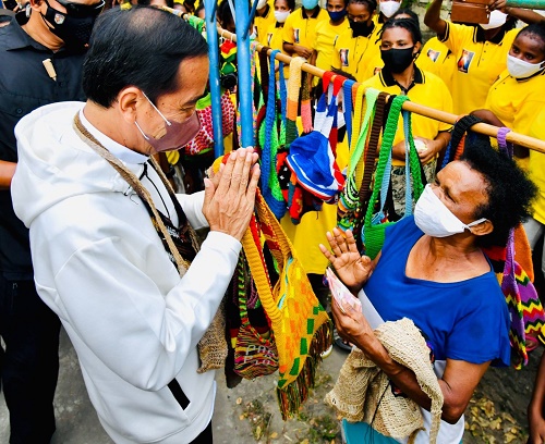 Presiden Jokowi membeli noken dari mama penjual di pinggir Jalan Raya Hawai Sentani, Jayapura, Papua, Jumat (01/10/2021). (Foto: BPMI Setpres/Laily)