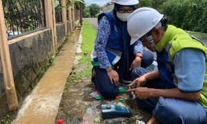 petugas bersama Kepala Cabang Pelayanan Kedung Halang Afriliyani mengecek tingkat kadar kekeruhan air menggunakan Turbidimeter di saluran pembersihan Perumahan Duta Kencana 2